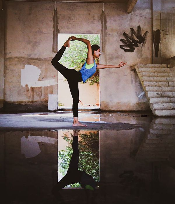 Woman performing a graceful yoga pose in a bright, calm room.